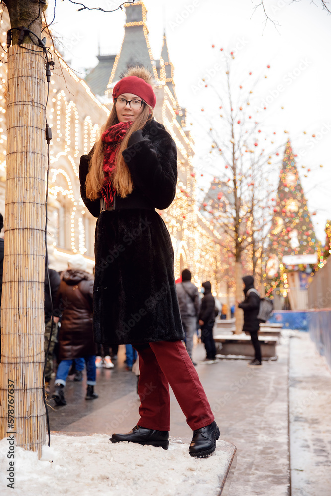 Winter portrait of young happy woman in wearing warm clothes. Concept tourist travel Christmas holidays Russia Red square