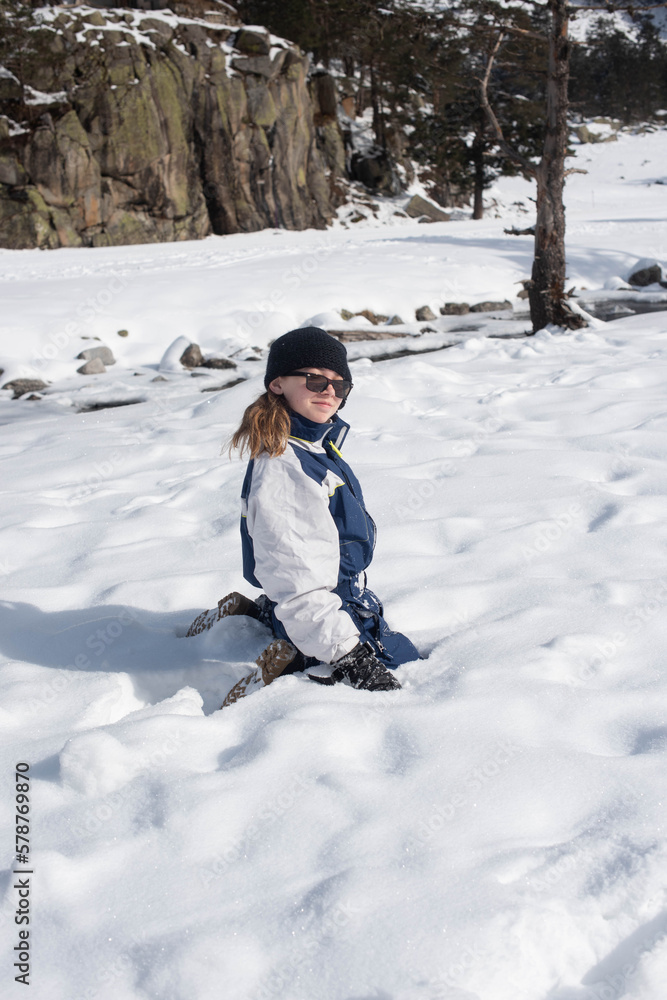 Cute smiling young girl playing in a beautiful snowy mountains landscape Cute smiling young girl playing in a beautiful snowy mountains landscape