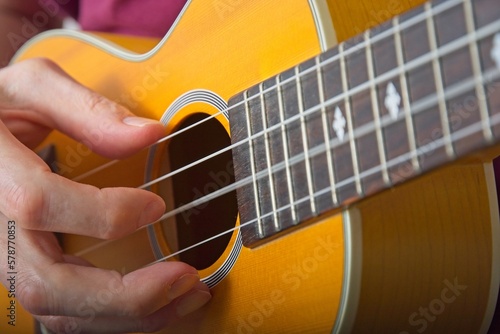 Close up fingerpicking ukulele with string motion blur photo