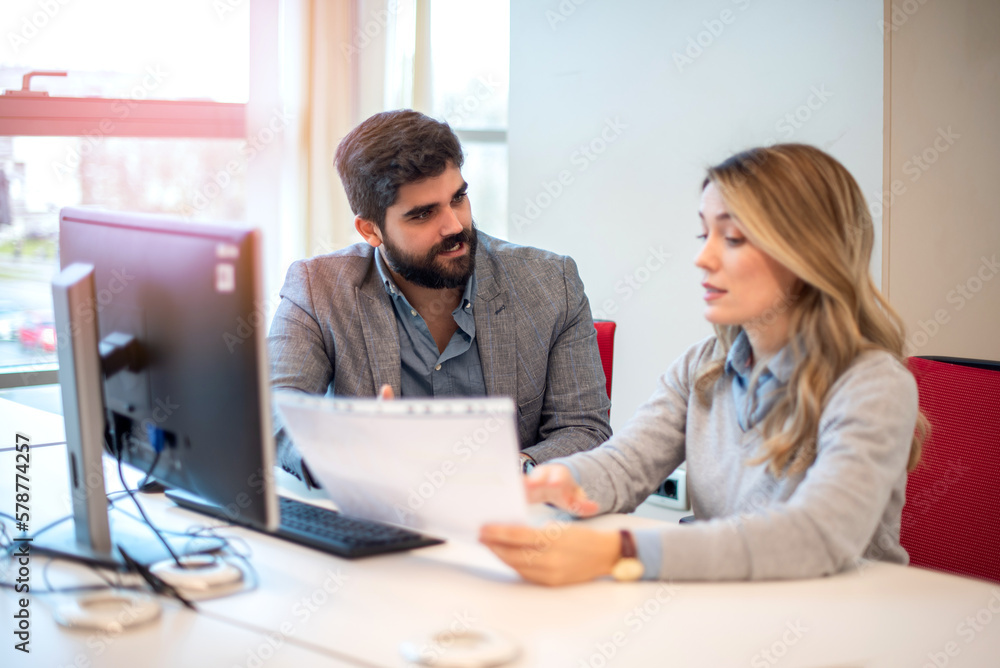 Business woman showing important business document to her male colleague at a meeting in office. Business woman showing important business document to her male colleague at a meeting in office.