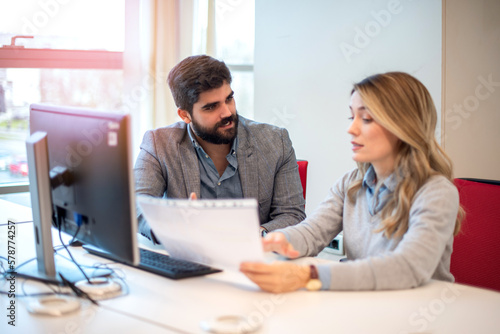 Business woman showing important business document to her male colleague at a meeting in office.