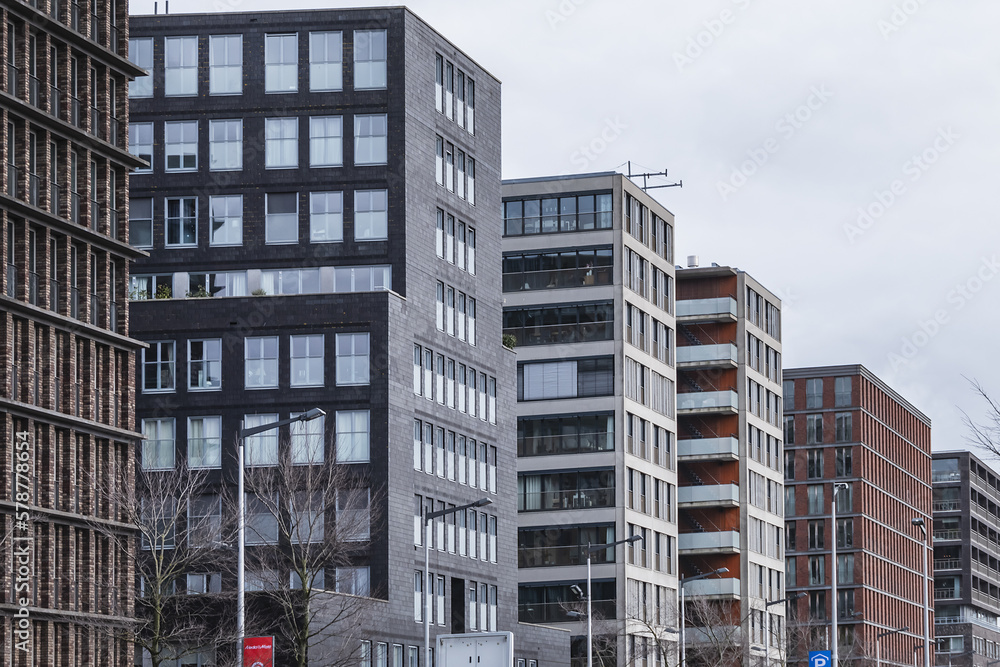 View of high-density residential and business area on the banks of the IJ River at the Oostelijke Handelskade (Eastern Docklands). Amsterdam, The Netherlands. View of high-density residential and business area on the banks of the IJ River at the Oostelijke Handelskade (Eastern Docklands). Amsterdam, The Netherlands.