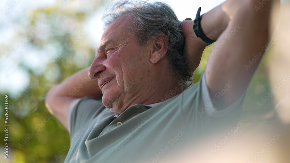 One relaxed happy retired senior man at outdoors park with hands behind head in contemplation. Pensive mature older person One relaxed happy retired senior man at outdoors park with hands behind head in contemplation. Pensive mature older person