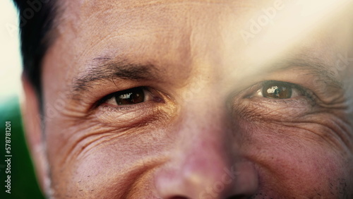 Portrait of a smiling man with wrinkles. Macro Close Up of male person with lens flare sunlight outdoors. Happy emotion expression