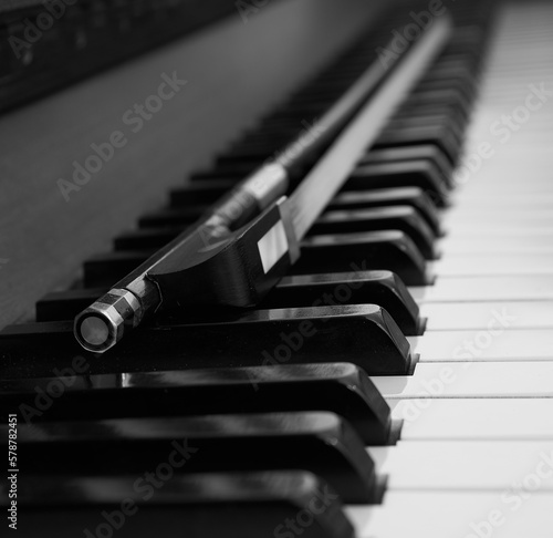 Piano keyboard with a violin bow