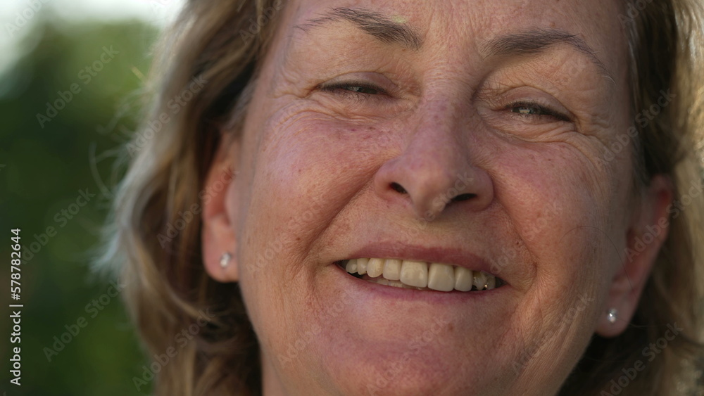One happy senior woman laughing. Portrait of a mature female person authentic real life smile looking at camera standing outdoors One happy senior woman laughing. Portrait of a mature female person authentic real life smile looking at camera standing outdoors