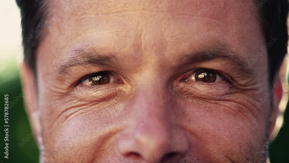 Macro close up of a man in 40s looking at camera smiling with wrinkles