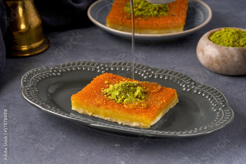 Middle eastern sweets kunefe, kunafa, kadayif with pistachio and syrup .Turkish , arabic traditional dessert. photo