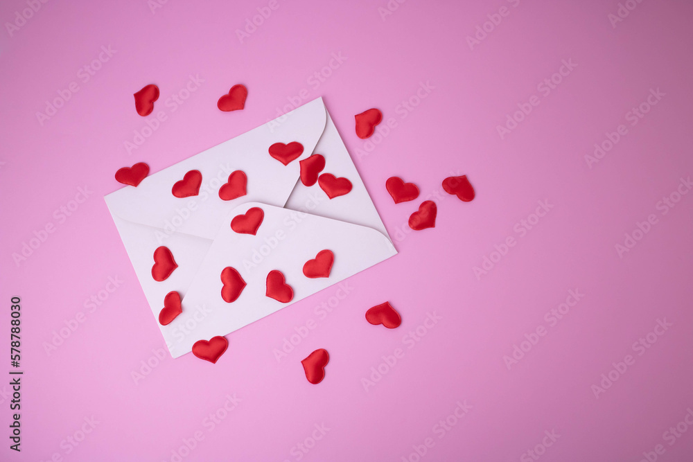 White envelope with red hearts for Valentine's Day on a pink background. The concept of a love message for March 8, Mother's Day, Father's Day, family Day.