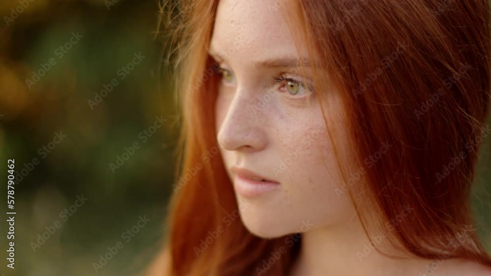 Beautiful young woman opens her eyes without looking at the camera, with natural make-up. Attractive girl with freckles on her face. A red-haired woman with a charming appearance Beautiful young woman opens her eyes without looking at the camera, with natural make-up. Attractive girl with freckles on her face. A red-haired woman with a charming appearance