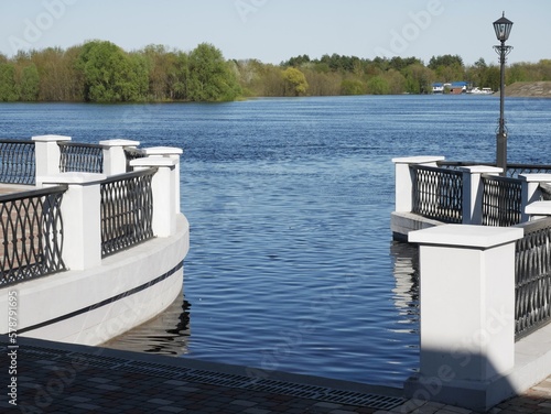 Fototapeta Naklejka Na Ścianę i Meble -  White fence on embankment of river in city
