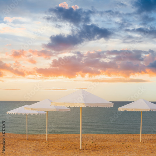 closeup sun umbrella stay on sandy sea beach at the evening