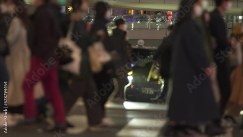 夜の渋谷駅近くの交差点を行き交う人混みと車