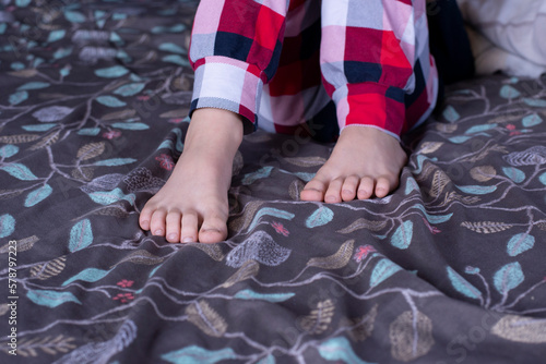 Bare feet of a child. Foot. Children in pajamas in bed