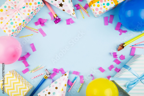 Birthday party attributes. Colorful balls, confetti, gifts, candles for cake. Blue background. Top view. Copy space