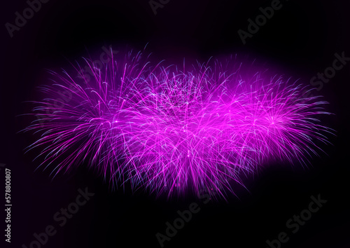 Beautiful purple fireworks display lights up the sky with dazzling display during New Year celebration. Abstract colored fireworks background with copy space. Celebration and anniversary concept