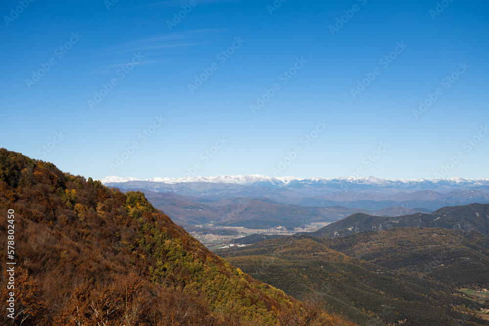 Landscape of red forest with snowy mountains in background, Catalonian winter, Spain Landscape of red forest with snowy mountains in background, Catalonian winter, Spain