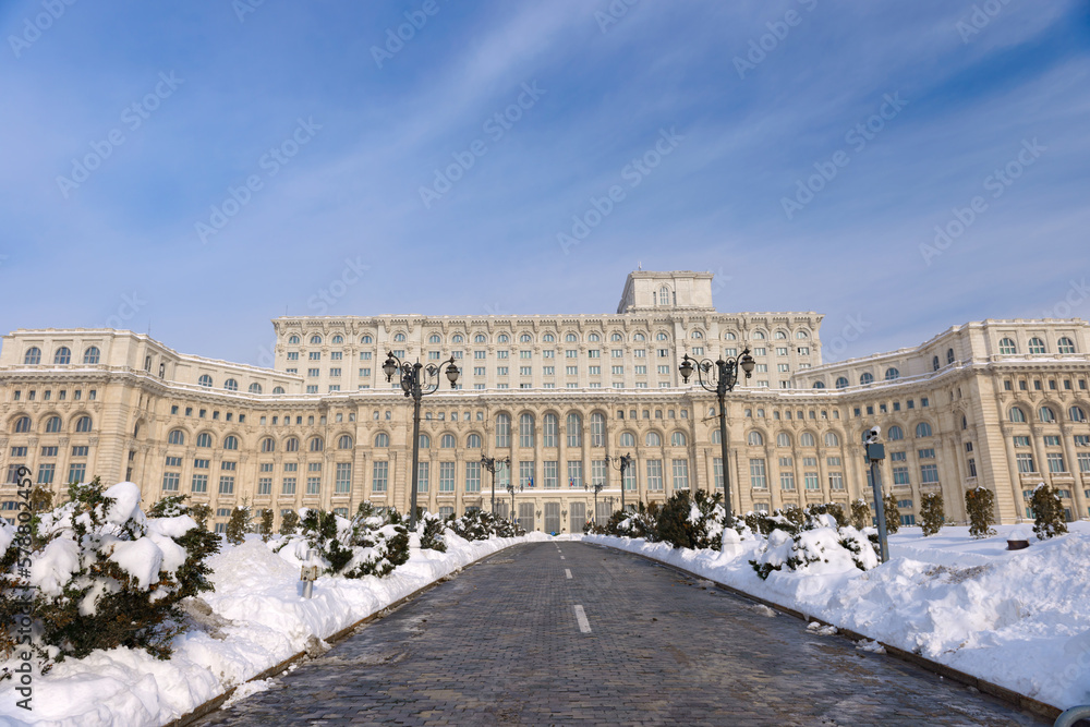 Large building of the Palace of the Parliament also known as People's House (Casa Poporului) in Constitutiei Square (Piata Constitutiei) in Bucharest, Romania, East Europe, in snowy winter scenery