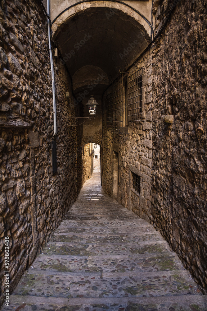 Medieval narrow stone street with tunnel in Girona, Spain