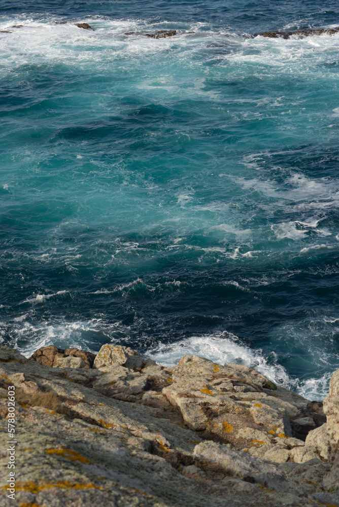 Blue sea with waves along the rocky shore Blue sea with waves along the rocky shore