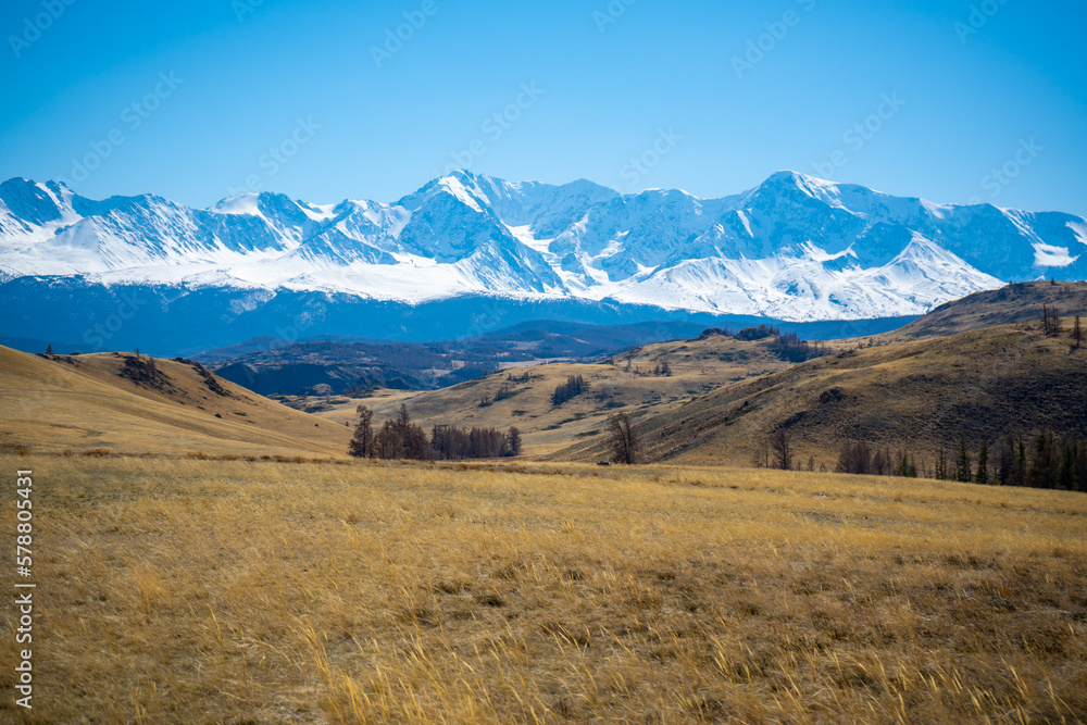 Scenic view with the beautiful mountain peaks with snow and glaciers, blue sky and the valley in the sunlight in Altai, Russia