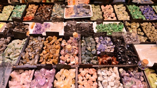 Colored stones of different sizes lying on a shelf. Exhibition of semi-precious stones.