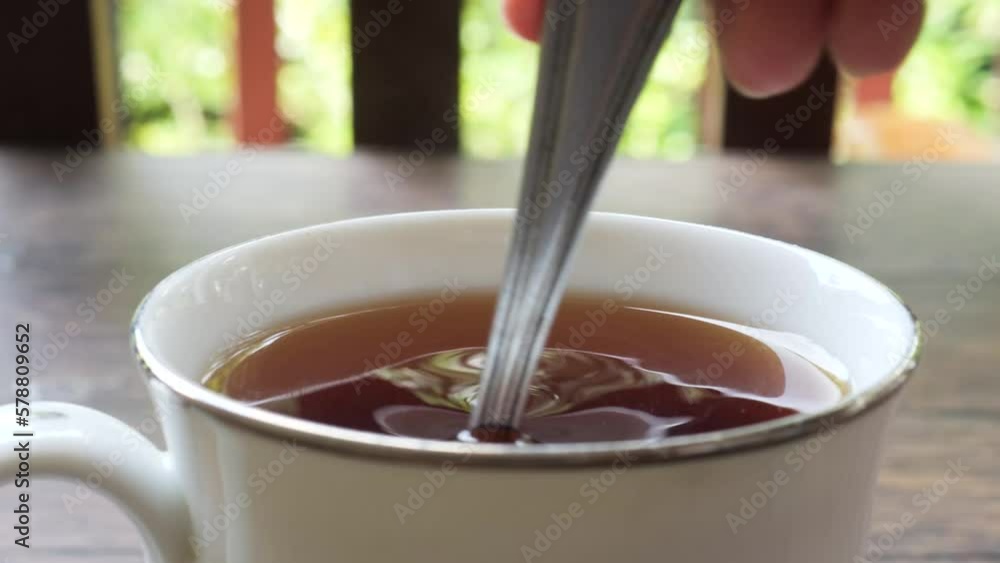 Stiring black tea with a spoon. Stiring black tea with a spoon.