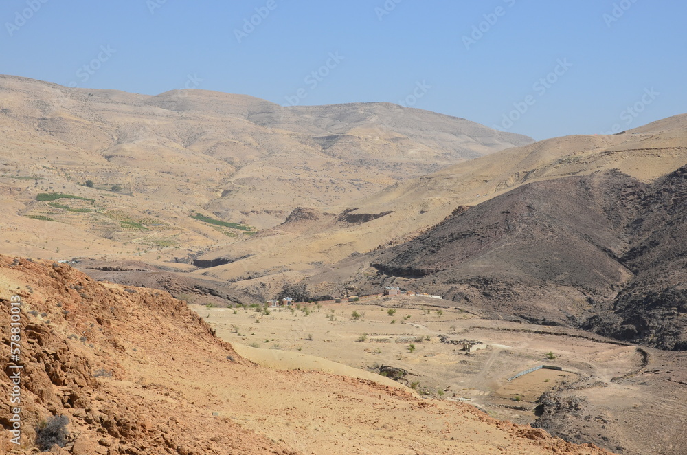 Panoramic view of the rocks, canyons and the desert and dry landscape surrounding Madaba, Jordan, on a bright sunny day.