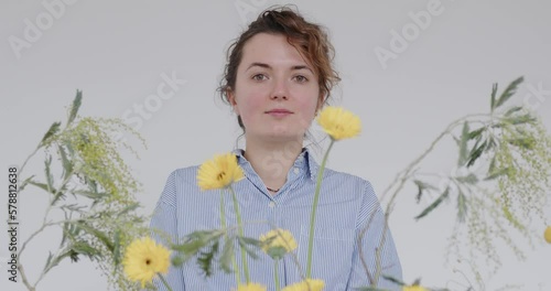 female doing new bouquet. Girl working in flower shop studio. Female florist artist cleans flowers for a beautiful bouquet, workplace view. High quality 4k footage