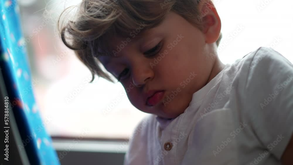 One bored little boy inside moving bus feeling upset. Angry kid closeup face with serious expression annoyed on road
