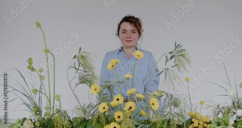 female doing new bouquet. Florist makes a floral oasis. Girl working in flower shop studio. Female florist artist cleans flowers for a beautiful bouquet, workplace view. High quality 4k footage