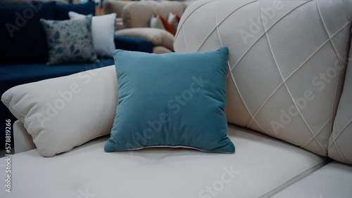 Zoom frame to a soft blue pillow sitting on a white couch. Minimalistic concept. 4k video.
