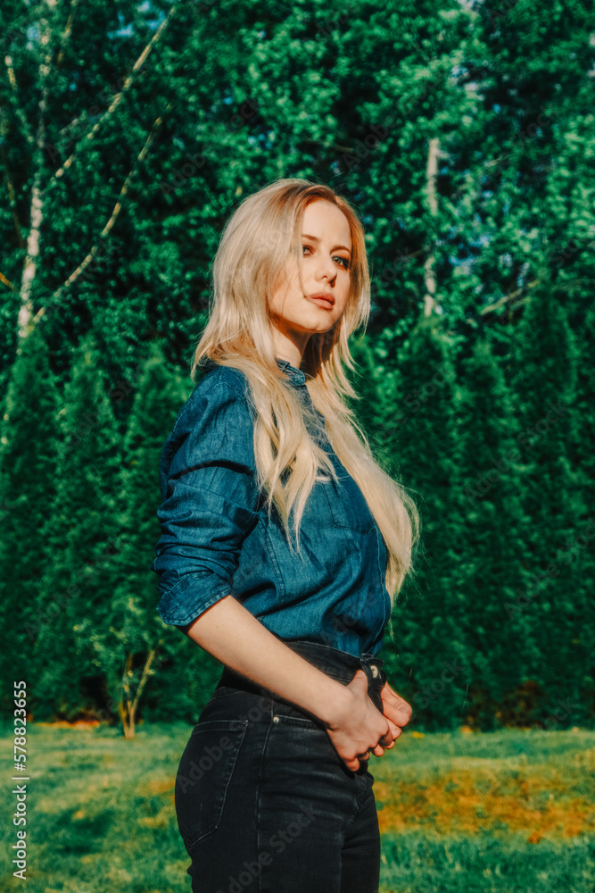 Beautiful blonde in demin shirt with trees on background in outdoor Beautiful blonde in demin shirt with trees on background in outdoor