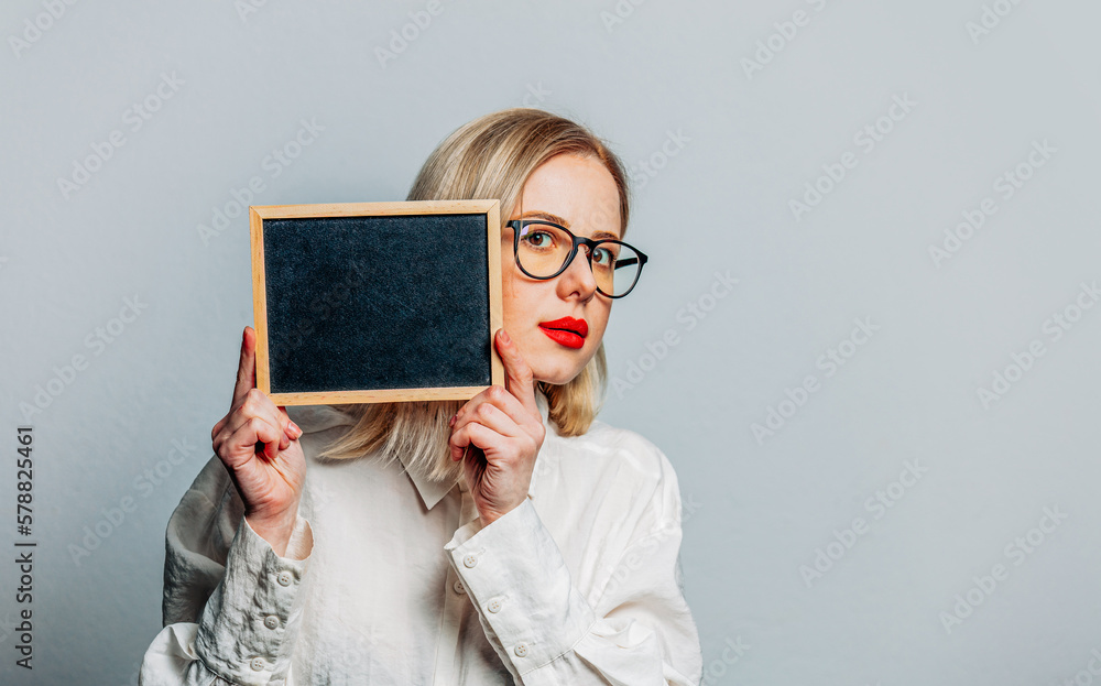 Portrait of beautiful blonde in white shirt with blackboard on white background Portrait of beautiful blonde in white shirt with blackboard on white background
