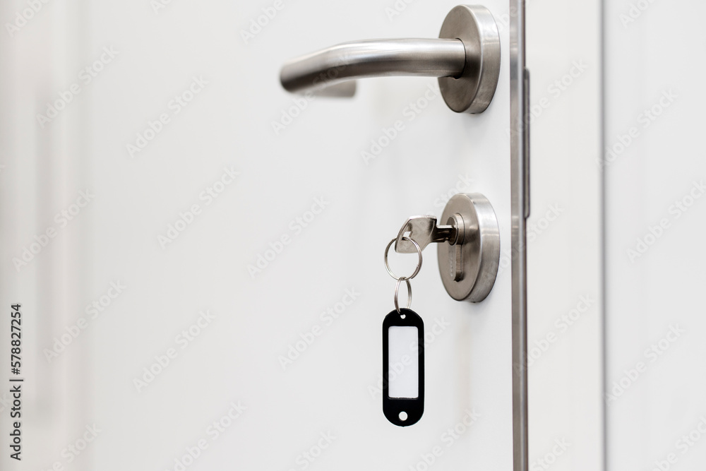 White door, door handle, door lock with key. Copyspace, place for text. White door, door handle, door lock with key. Copyspace, place for text.