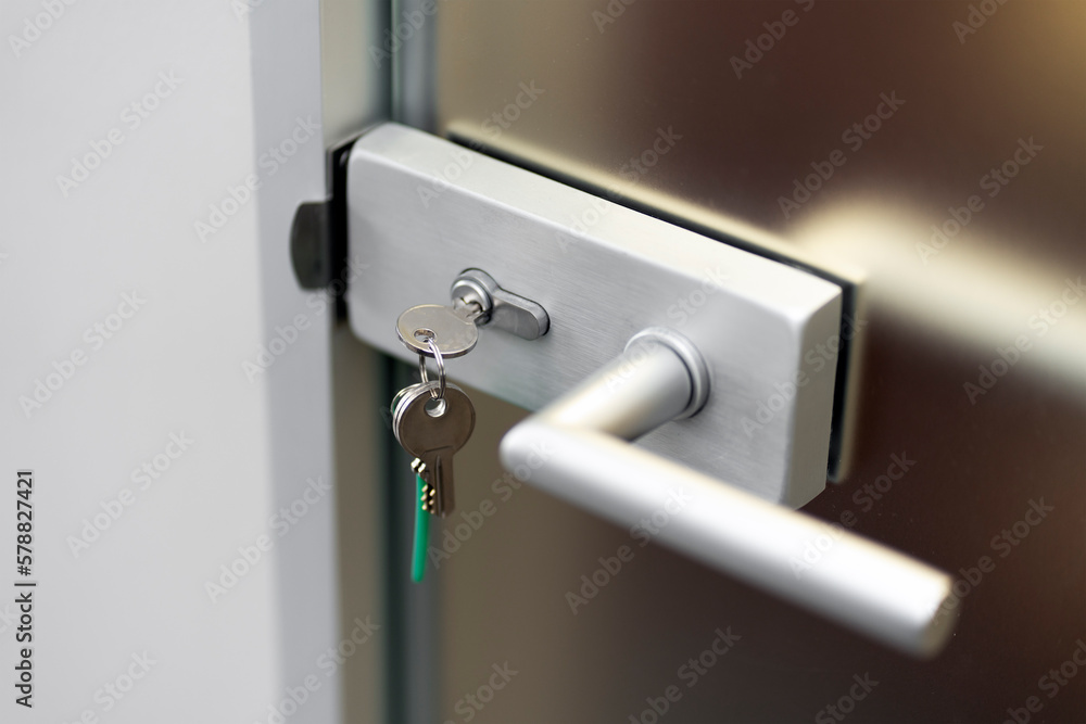 Modern door, key in the core of the lock, secure lock, security concept, closed door, closeup. Modern door, key in the core of the lock, secure lock, security concept, closed door, closeup.