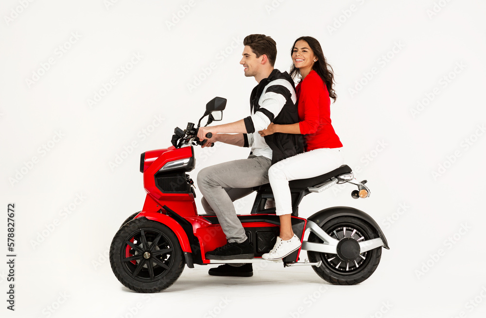young attractive couple riding an electric motorbike scooter happy having fun together young attractive couple riding an electric motorbike scooter happy having fun together