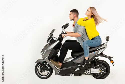 young attractive couple riding an electric motorbike scooter happy having fun together