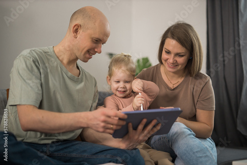 Deaf child girl with cochlear implant studying to hear sounds and have fun with mother and father - recovery after cochlear Implant surgery and rehabilitation concept