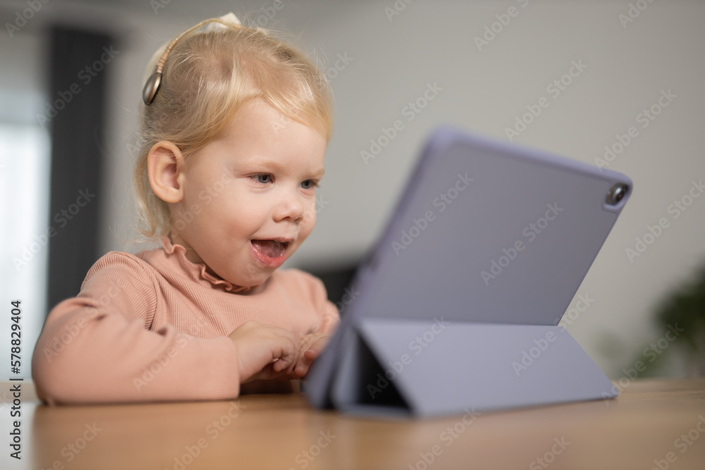 Deaf child girl with cochlear implant studying to hear sounds - recovery after cochlear Implant surgery and rehabilitation concept Deaf child girl with cochlear implant studying to hear sounds - recovery after cochlear Implant surgery and rehabilitation concept