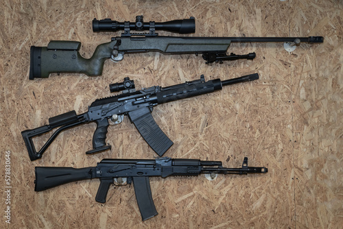 Tactical weapons hanging on the wall, sniper rifle, semi-automatic shotgun and ak 74m.