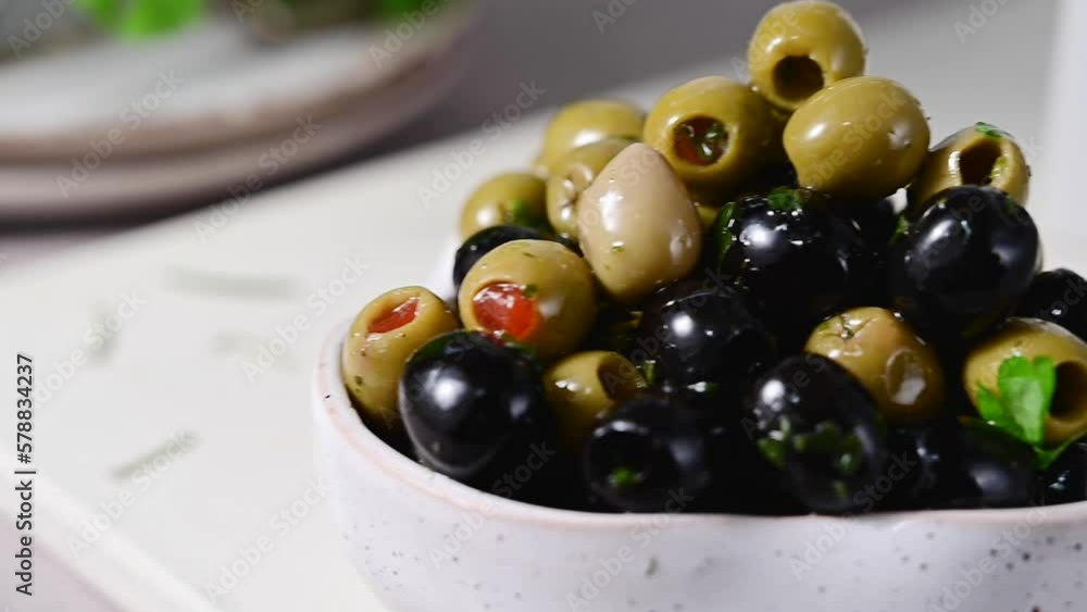 Black and green olives in a bowl. Delicious, marinated olives. Mediterranean food. Black and green olives in a bowl. Delicious, marinated olives. Mediterranean food.
