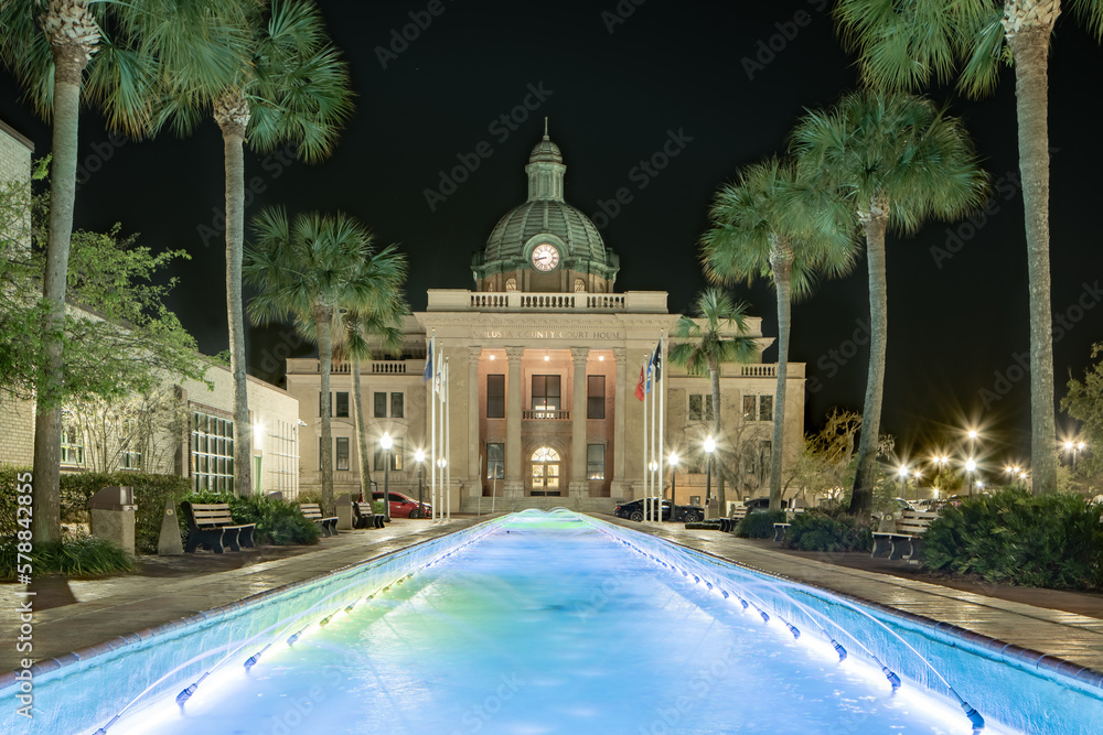 Fototapeta premium Evening photo of the historic Volusia County Courthouse and fountain pool in DeLand, Florida.