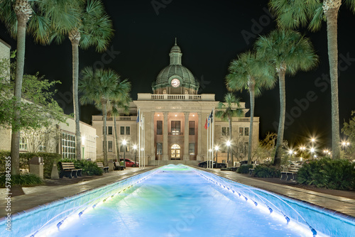 Evening photo of the historic Volusia County Courthouse and fountain pool in DeLand, Florida. photo