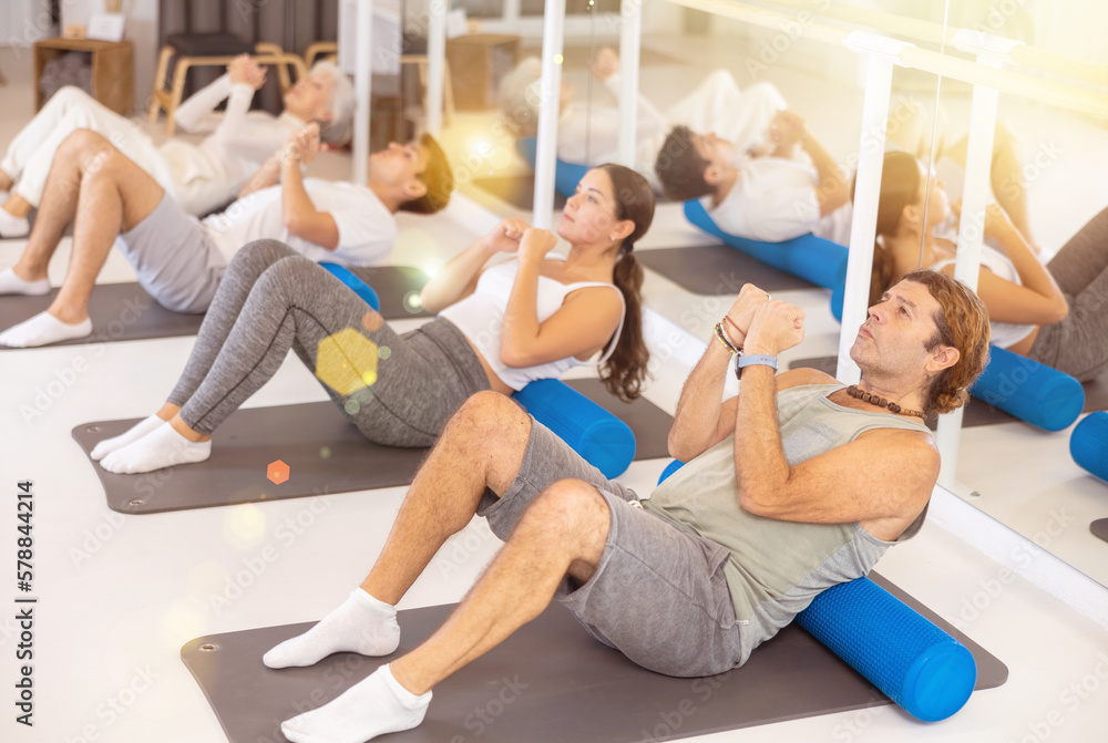 Fototapeta premium Group of people doing hip bridge exercise in the gym