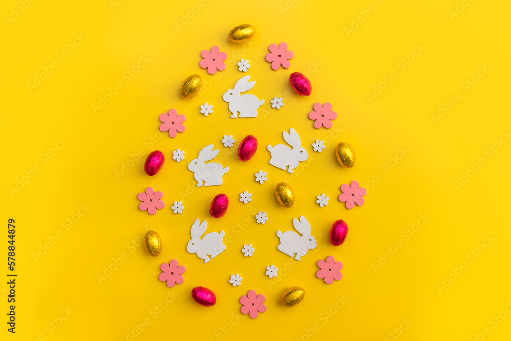 Flat-lay Easter decoration wooden flowers, rabbits and eggs on yellow background. Copy space. Flat-lay Easter decoration wooden flowers, rabbits and eggs on yellow background. Copy space.