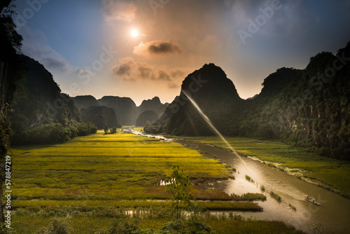 The boats carry tourists through the caves and rice fields on the Ngo Dong river at Tam Coc-Bich Dong area, a famous tourist destination in Ninh Binh province, Vietnam photo