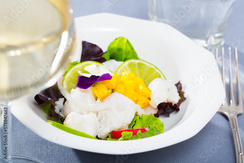 Cod ceviche with mango, lime and greens served on plate