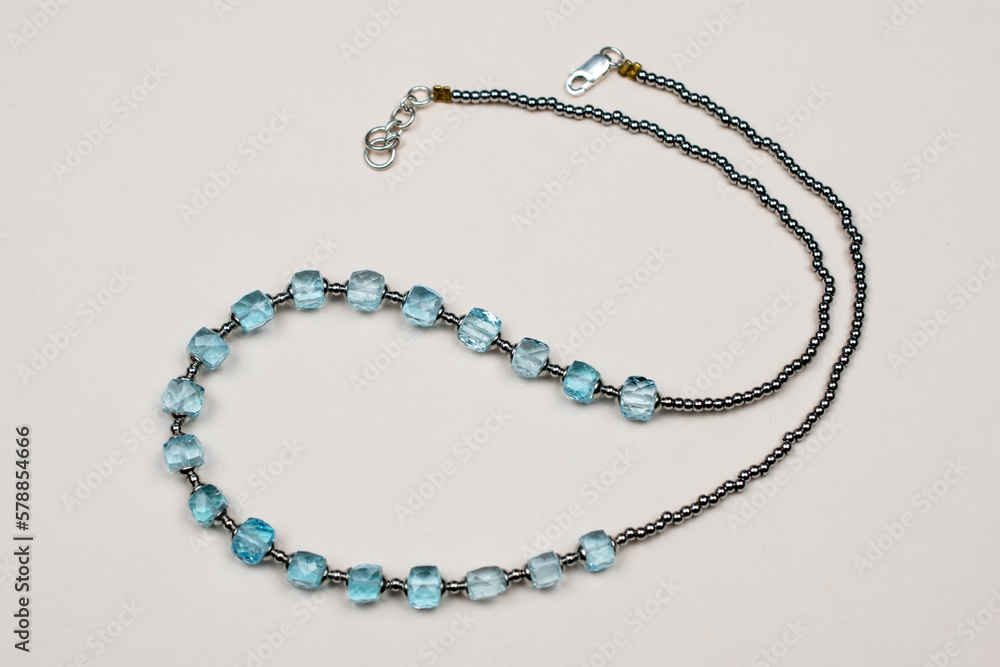 Colorful gemstone crystal beads necklace on white, unique handmade jewelry background Colorful gemstone crystal beads necklace on white, unique handmade jewelry background