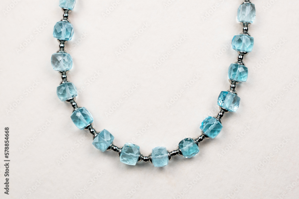 Colorful gemstone crystal beads necklace on white, unique handmade jewelry background Colorful gemstone crystal beads necklace on white, unique handmade jewelry background